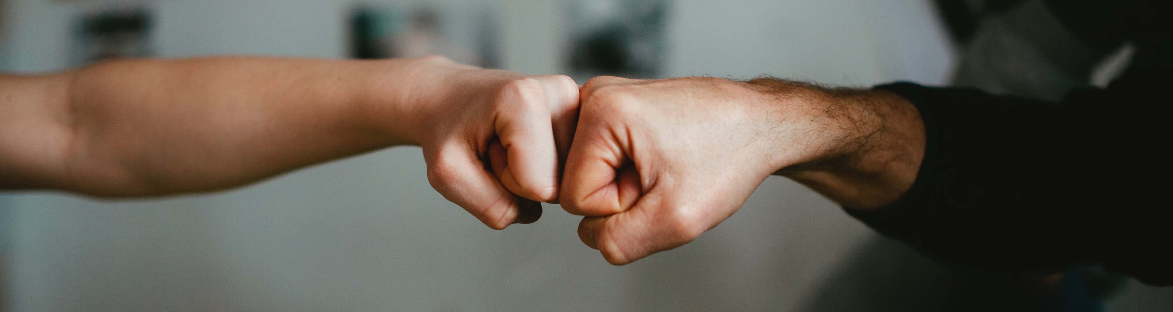 A client fistbumping with their service provider in a display of teamwork